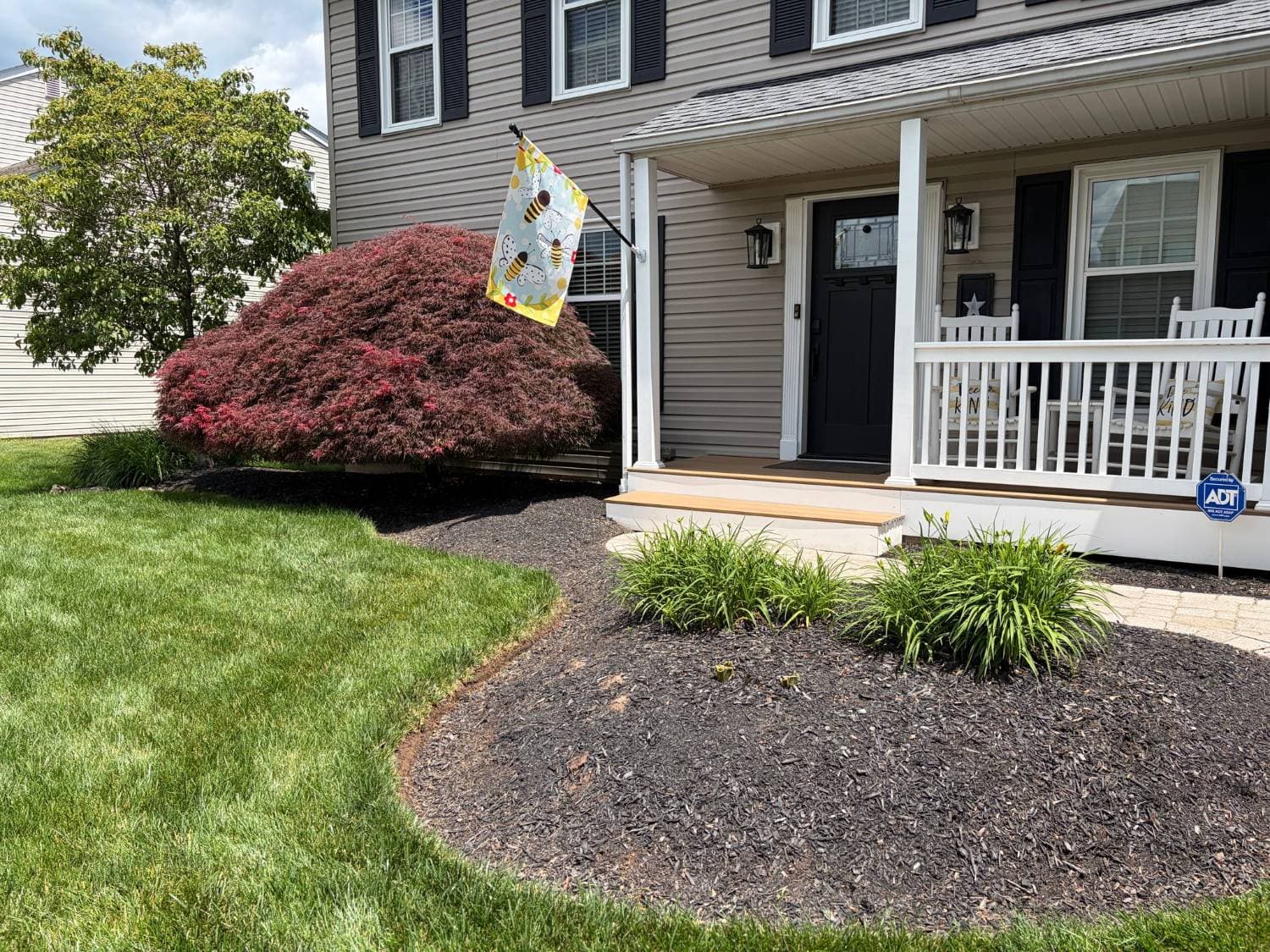 Front porch beds before a mulch refresh, with faded, thin mulch and soft edges