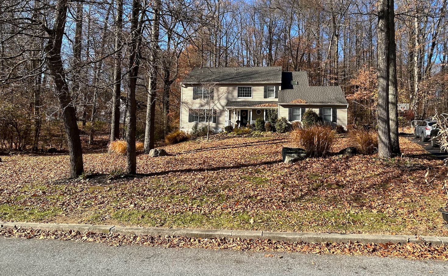 Front yard of a wooded Pottstown-area home buried in fallen leaves before cleanup
